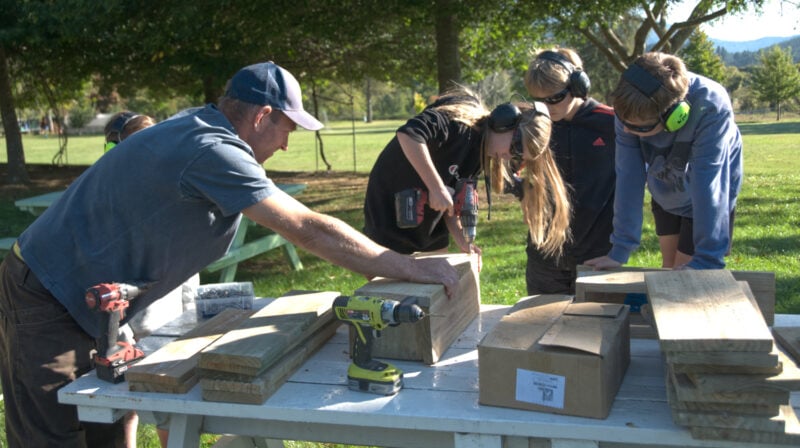 Farmers for Whio representative Barry Burger helps Ngatimoti School students build predator traps.