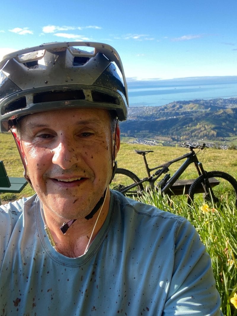 Howie Timms, General Manager Commercial at NBS, splattered with mud with his mountain bike in the background