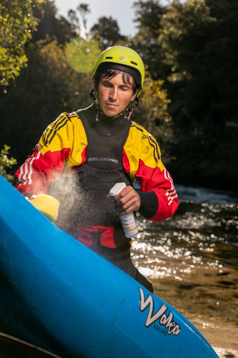 Paddler cleaning his kayak to stop the spread of freshwater pests