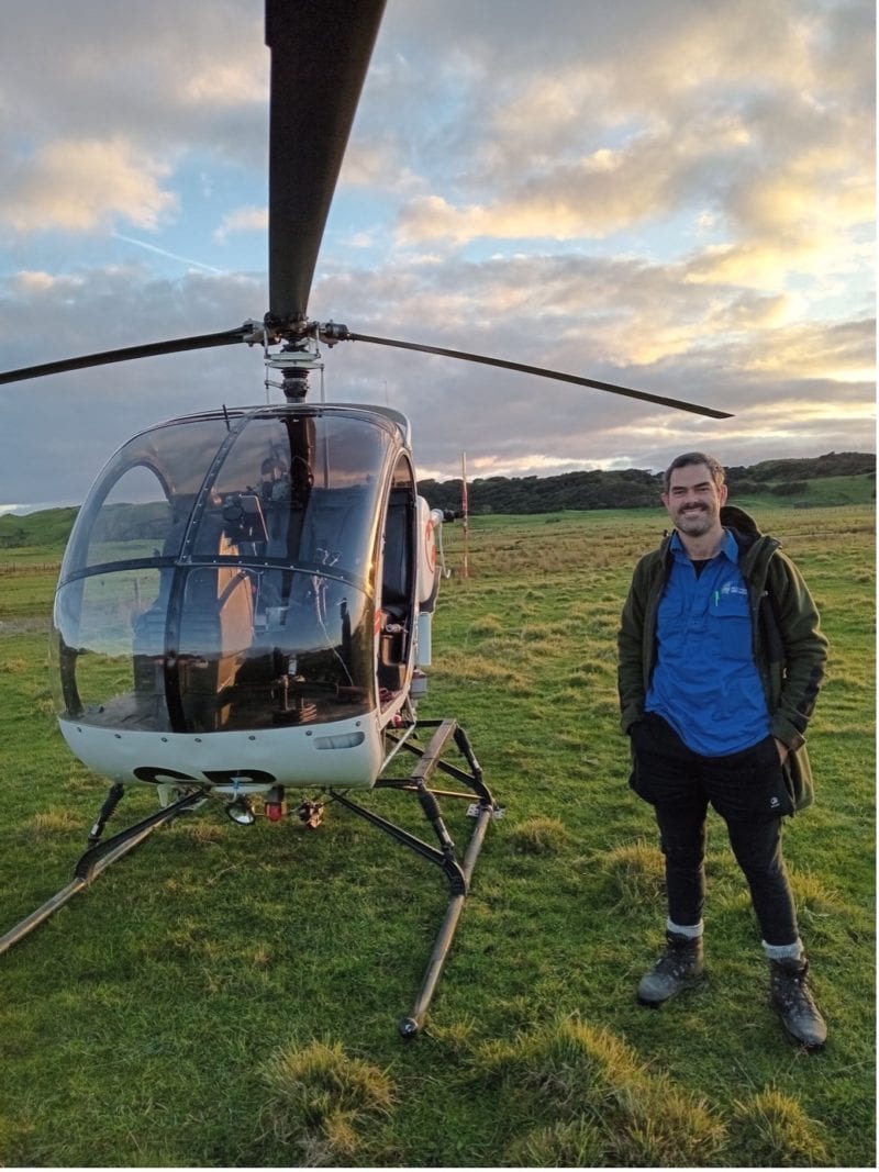 PFO’s Aaron McClatchy stands beside the helicopter used in the recent feral pig cull